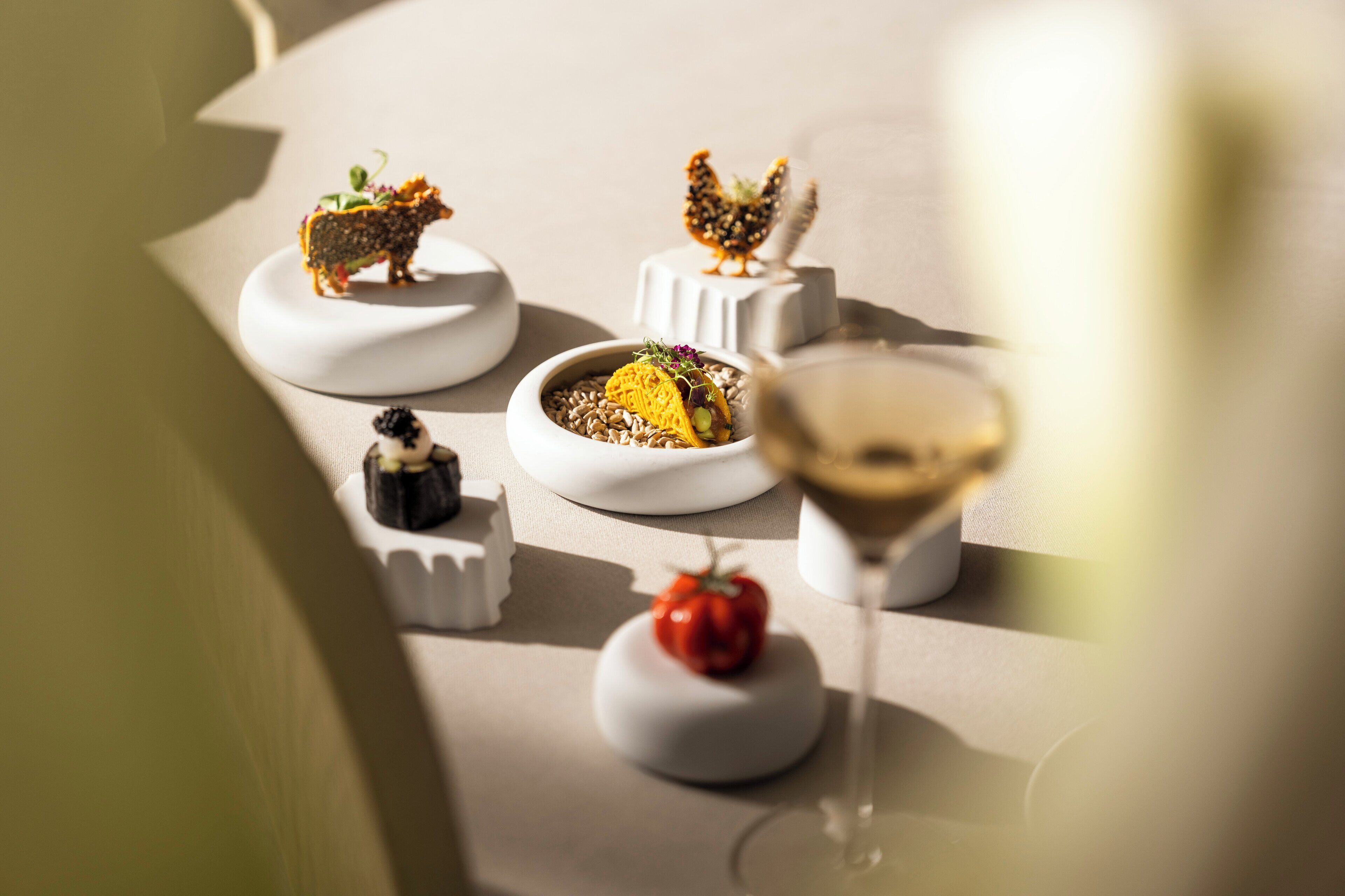 Una mesa servida con diversos alimentos y una copa de vino.