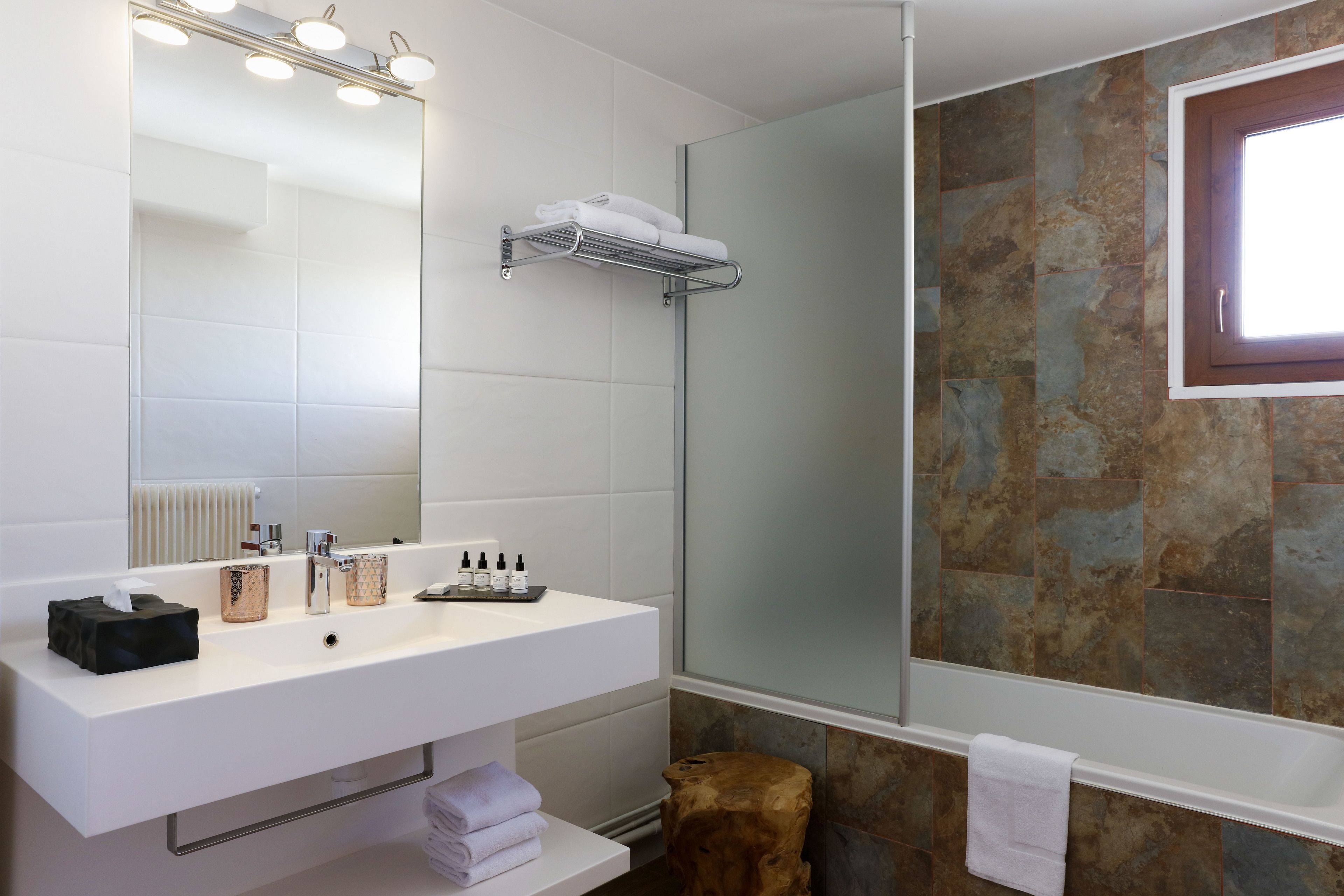 A modern bathroom with a white vanity, a large mirror, and a shower area.