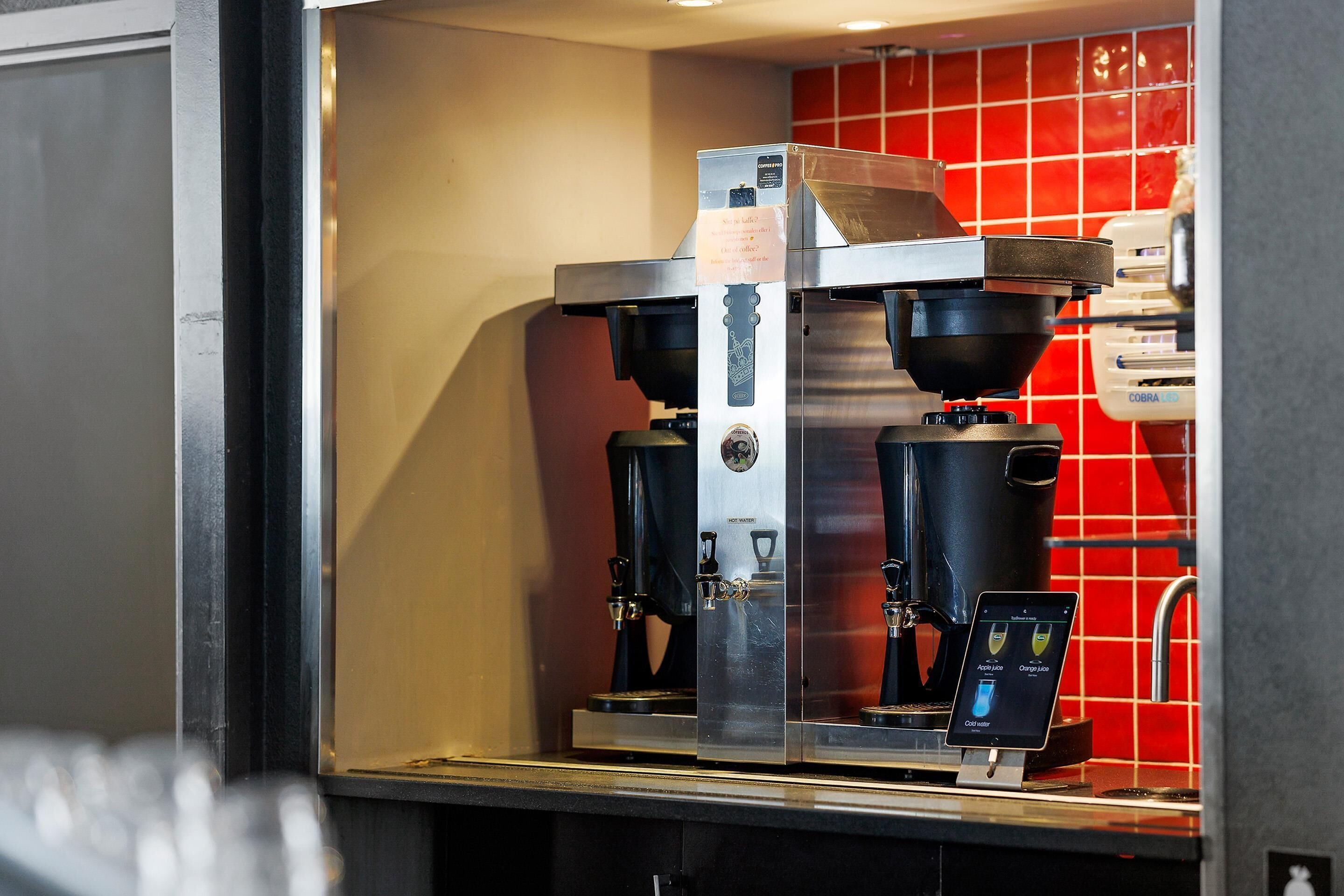 A coffee machine with a digital interface, a water dispenser, and a coffee grinder.