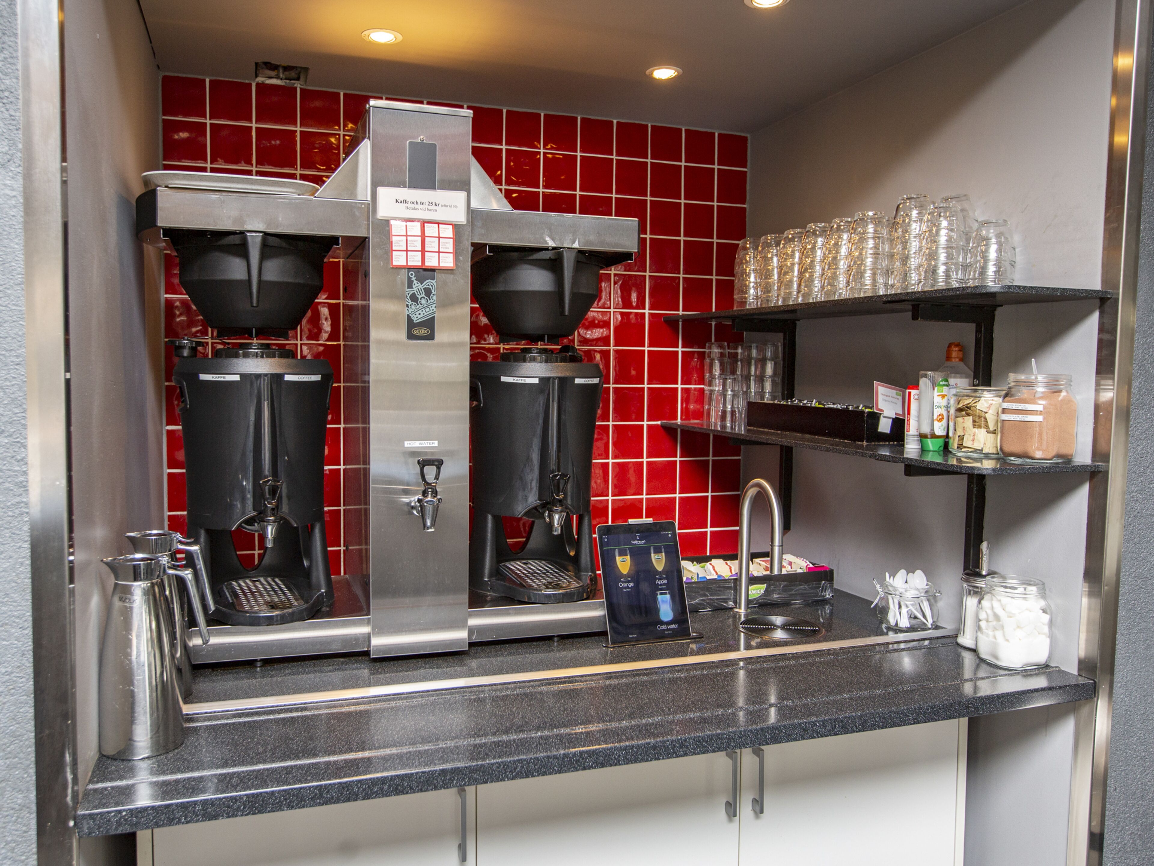 Kahvinurkkaus, jossa on kaksi espressokoneetta, vesiautomaatti ja kahvimylly.