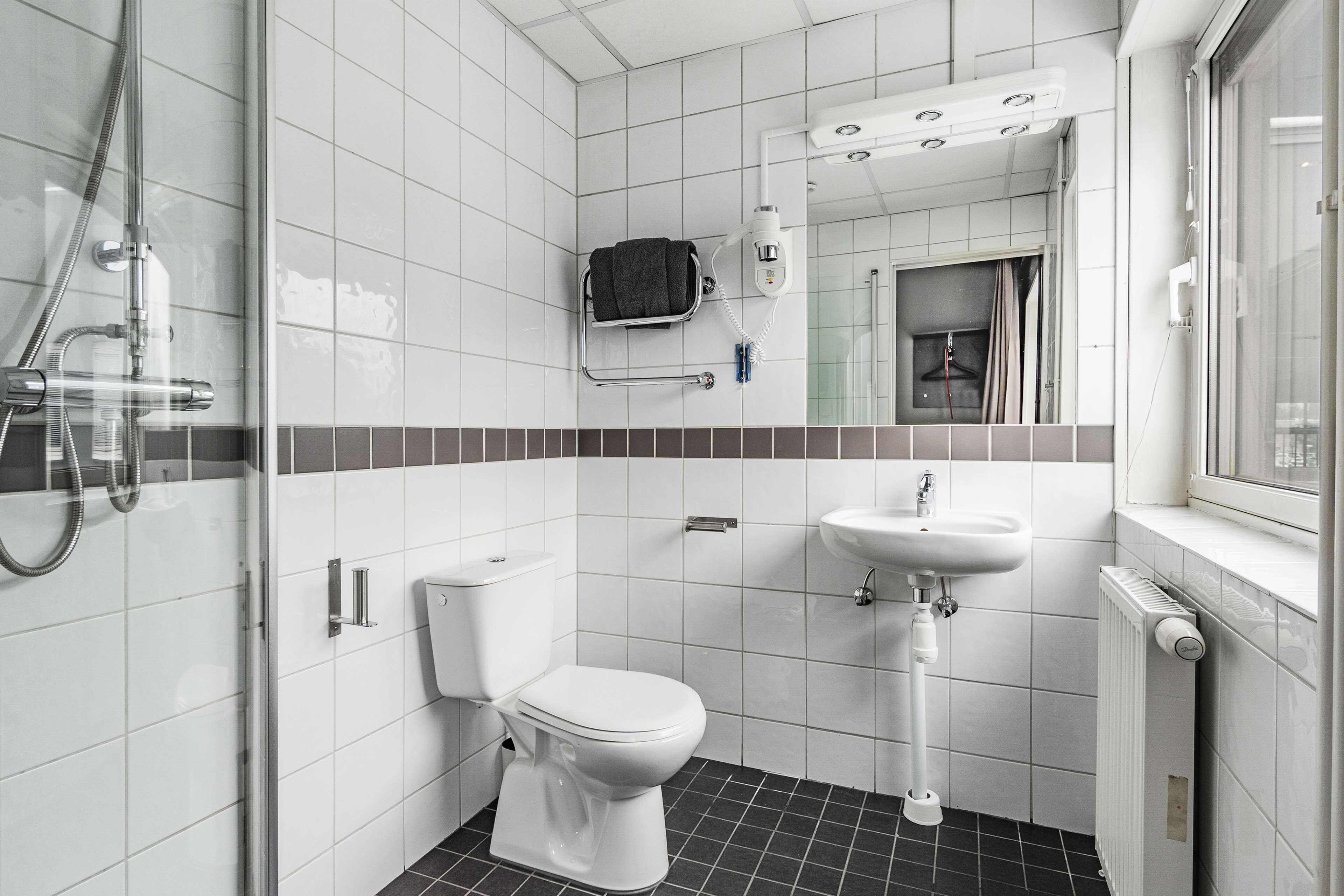 A modern bathroom with a toilet, sink, and shower.