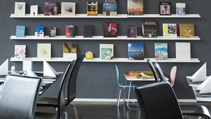 A modern library with bookshelves and chairs. - Aiden by Best Western Stockholm Arlanda Airport (Arlandastad)