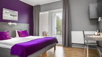 A modern bedroom with a bed, a desk, and a balcony.