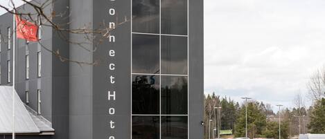 A modern hotel building with a large glass facade and a sign reading "Connect Hotel".