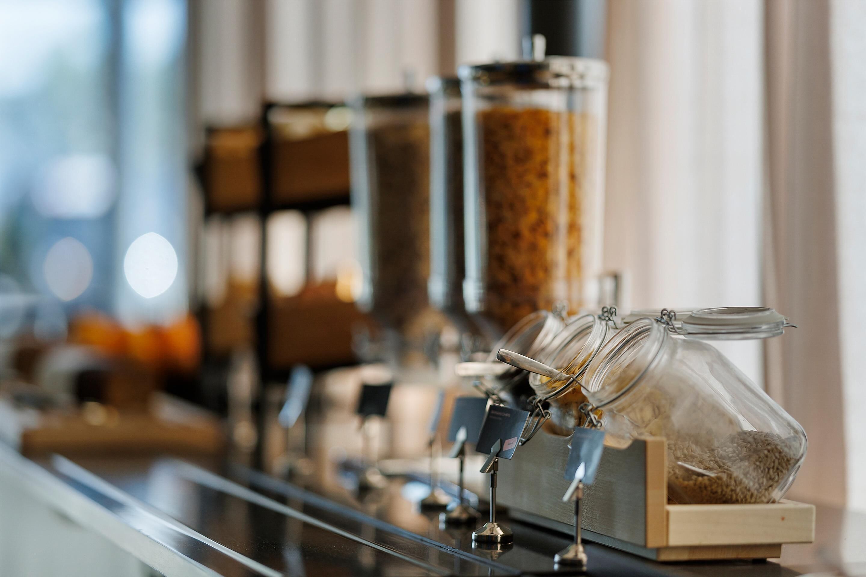 Una máquina de café con varios dosificadores, cada uno con un tipo diferente de grano o polvo de café.