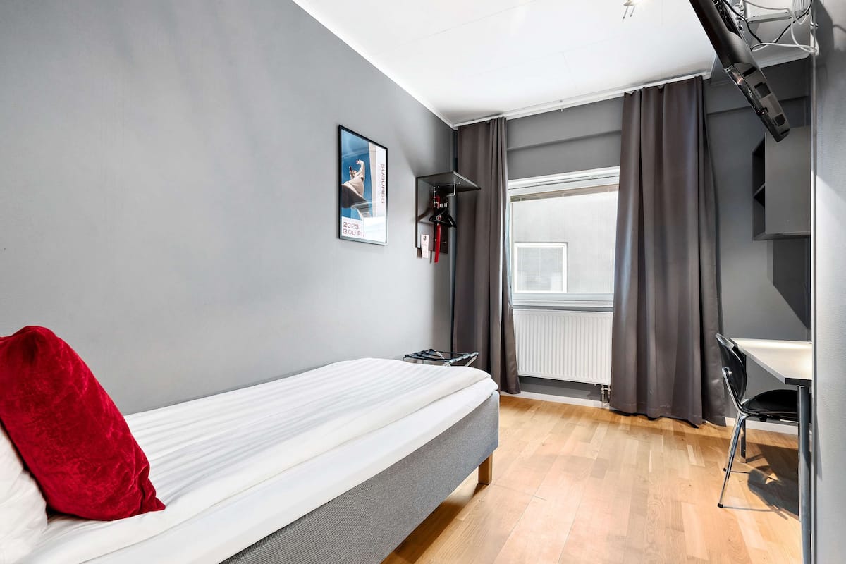 Une chambre moderne avec un lit, un bureau et une fenêtre avec des rideaux.