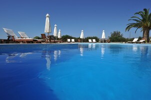 Una piscina al aire libre de temporada, sombrillas