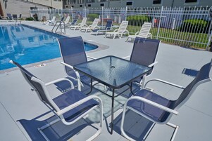 A poolside area with lounge chairs and a table.
