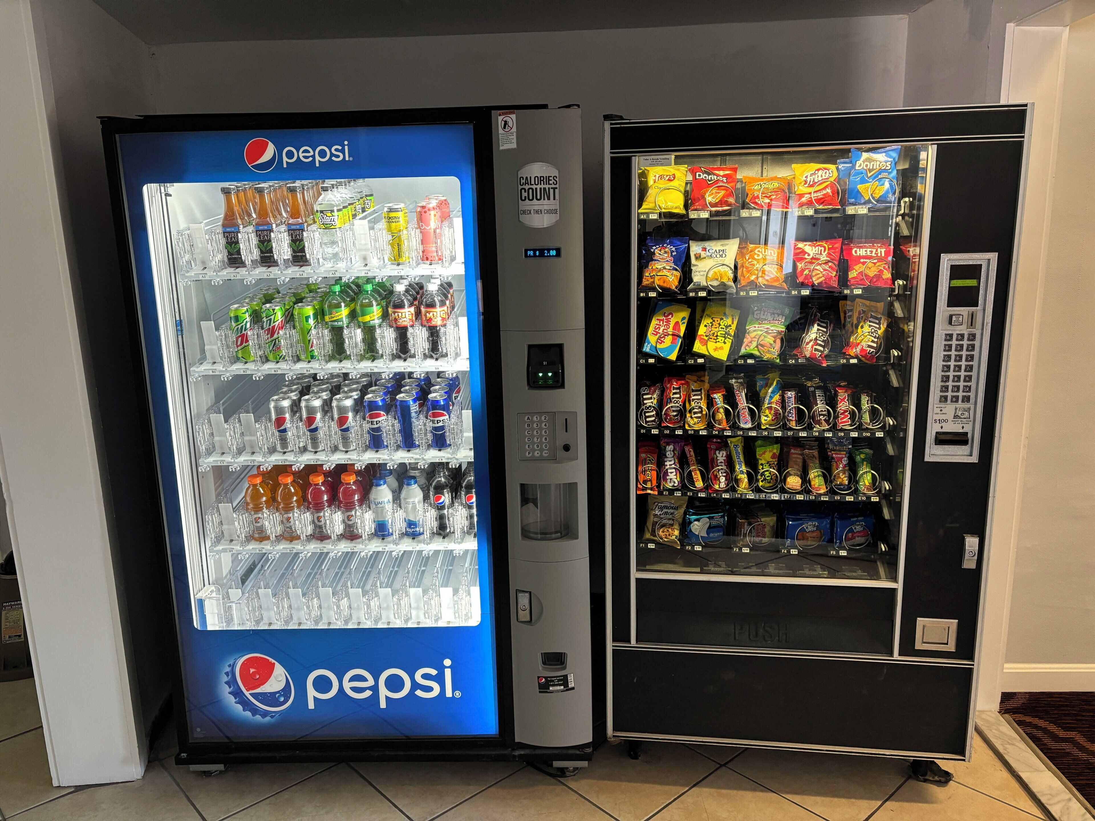 Duas máquinas automáticas, uma com bebidas Pepsi e outra com petiscos.