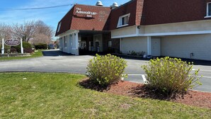 A brick building with a sign for 'The Admiralty Inn' and a covered entrance. - Admiralty Inn & Suites - a Red Collection Hotel (East Falmouth)