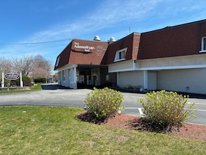 A brick building with a sign for 'The Admiralty Inn' and a covered entrance. - Admiralty Inn & Suites - a Red Collection Hotel (East Falmouth)