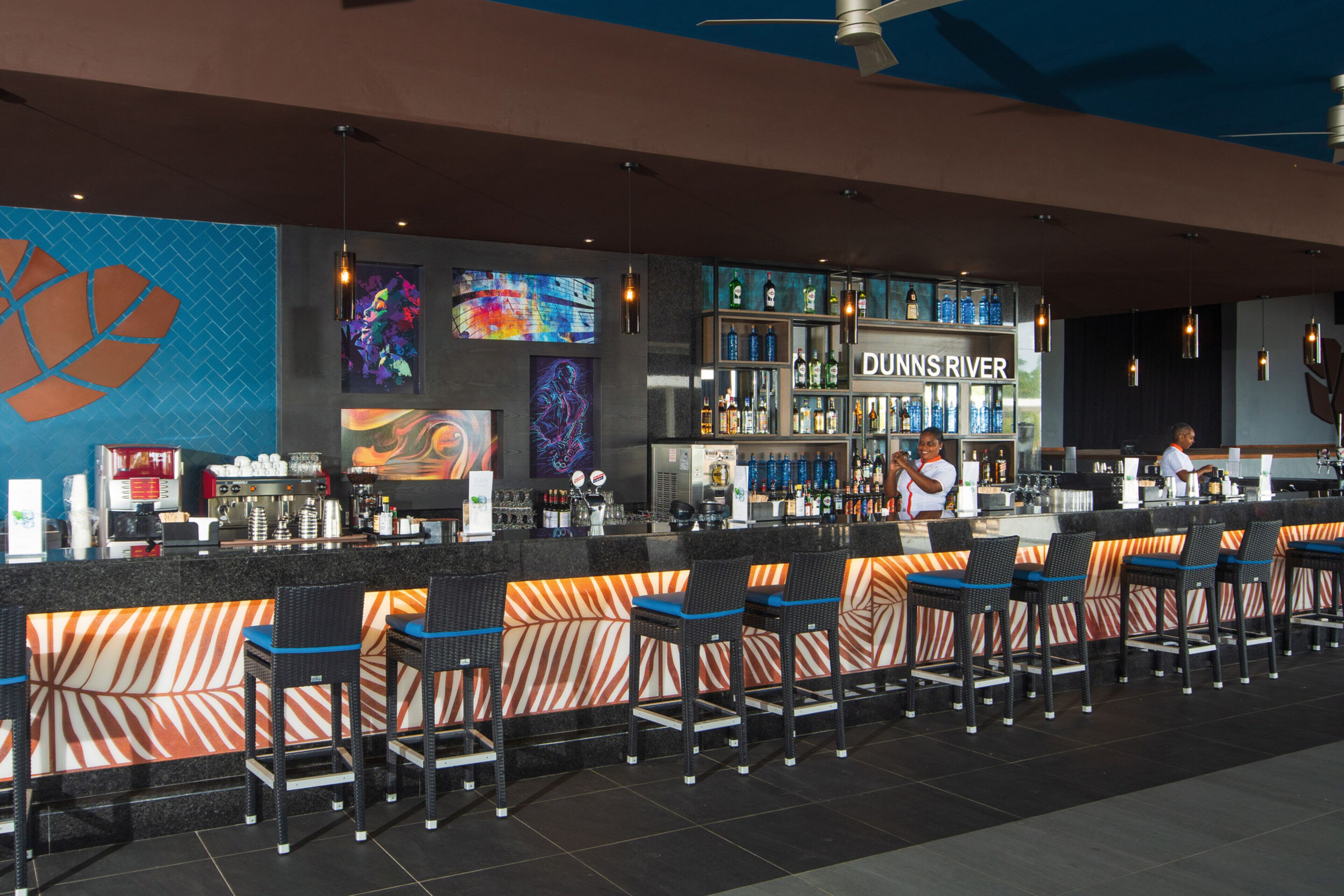 A bar area with a counter, bar stools, and a sign that reads "DUNNS RIVER".