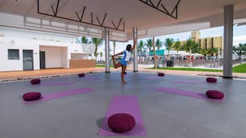 Amplio espacio interior con tapetes de yoga y una persona realizando una postura de yoga.