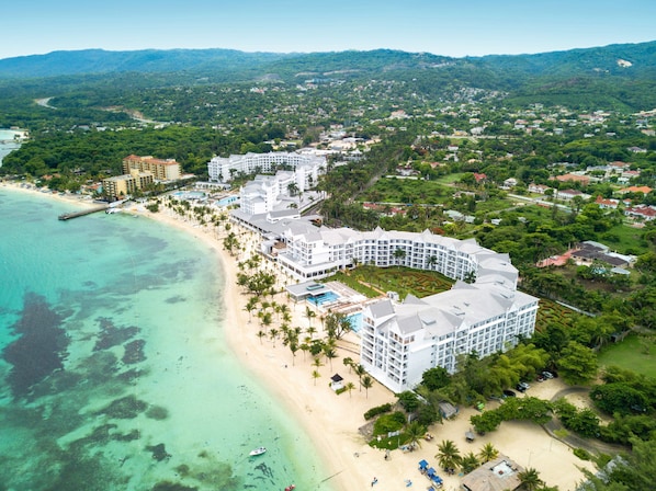 A resort with a beachfront, multiple buildings, and a pool area.