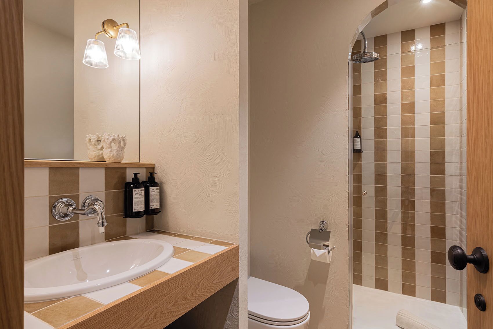 A bathroom with a sink, mirror, and shower.