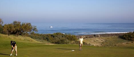 Un campo de golf con vista al océano.