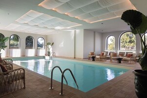 Una piscina cubierta, una piscina al aire libre de temporada, tumbonas
