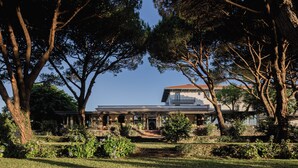 A two-story house with a covered patio and a garden. - Hotel Maison Chiberta (Anglet)