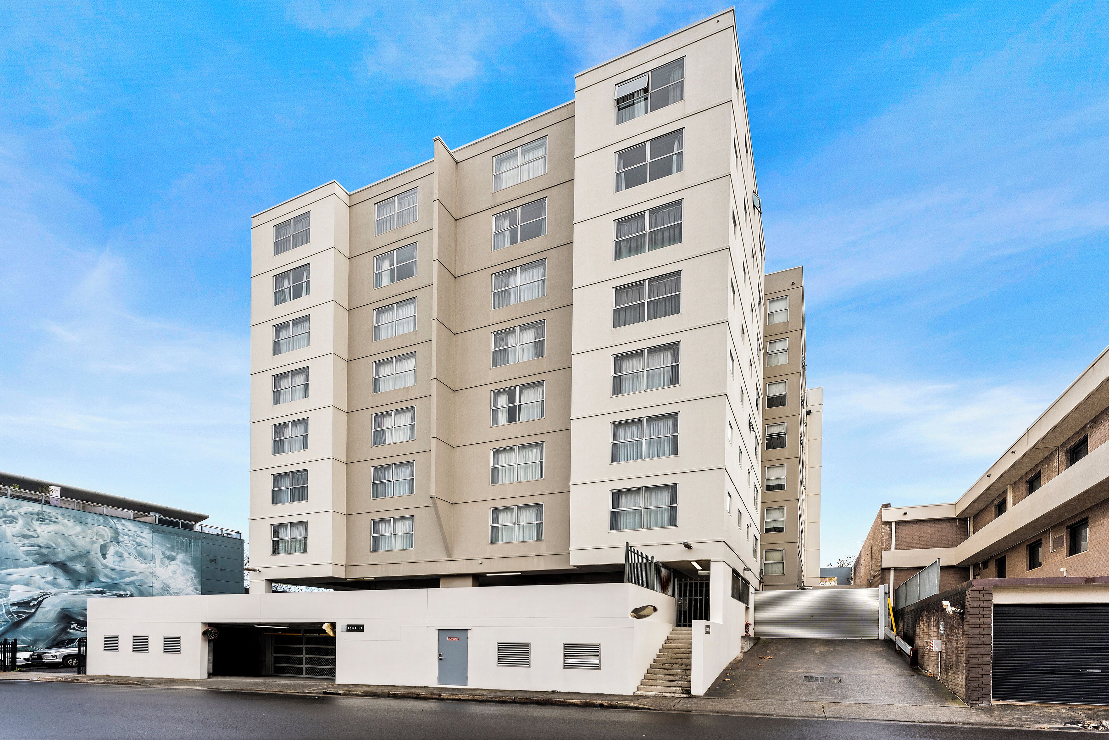 A multi-story building with a flat facade, large windows, and a garage entrance.