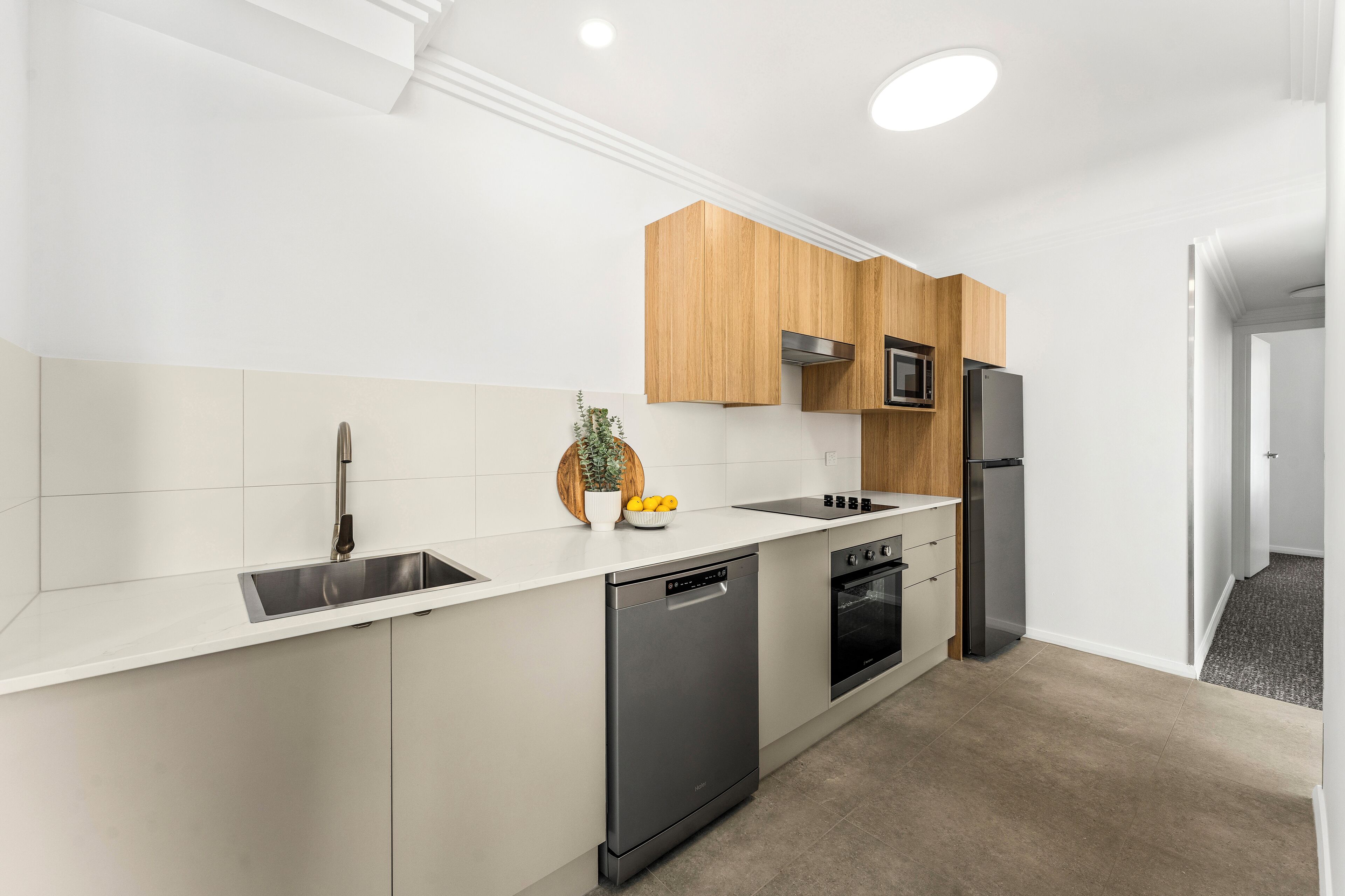 A modern kitchen with a dishwasher, oven, microwave, and a refrigerator.