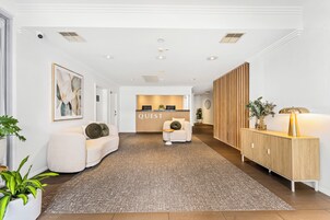 A hotel lobby with a reception desk, seating area, and a reception counter.