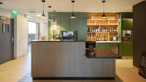 Un espace d’accueil comprenant un comptoir, un ordinateur et un téléviseur diffusant un menu.