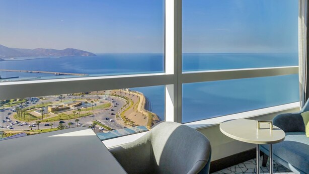 A balcony with a view of a coastal area, including a road and buildings. - Hotel Oran Bay Managed By Accor (Oran)