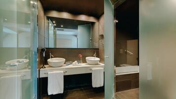 Un baño moderno con dos lavamanos, un espejo grande y una zona de ducha separada.