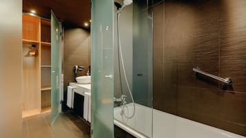 A modern bathroom with a glass-enclosed shower, a bathtub, and a vanity with a sink.