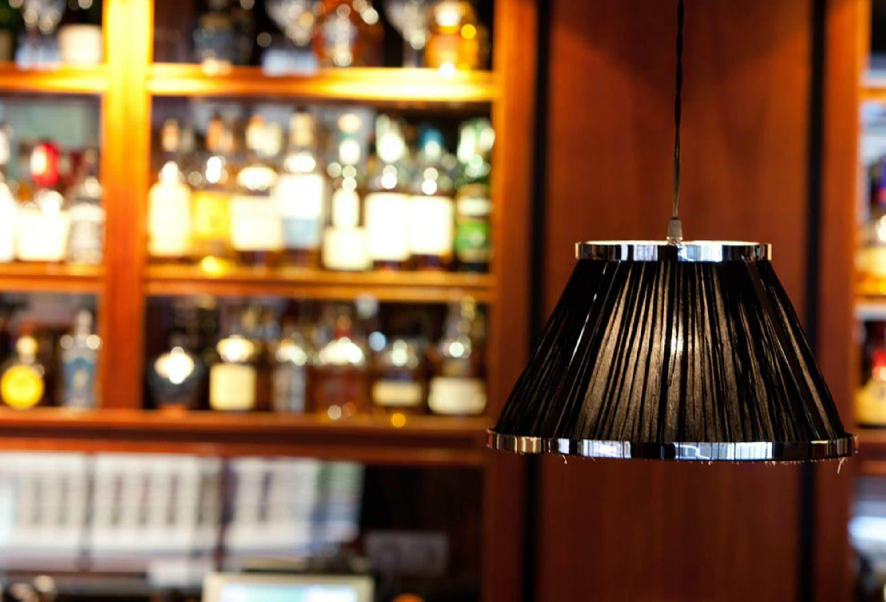 Una lámpara colgante con pantalla cónica en un bar.
