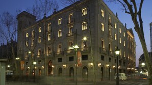 A historic building with multiple floors, large windows, and a central entrance with an arched doorway. - Hotel 1898 (Barcelona)