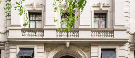 A historic building with a grand entrance, large black doors, and a classic architectural style.