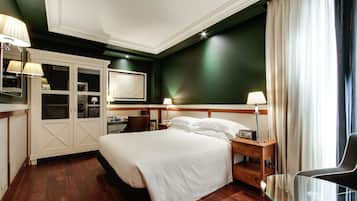 A hotel room with a large bed, bedside tables, a desk, and a chair.