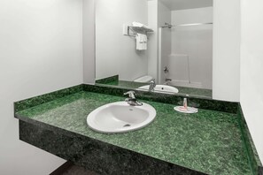 A bathroom with a white sink, green marble countertop, and a mirror above the sink. - Super 8 by Wyndham Central Pt Medford (Central Point)