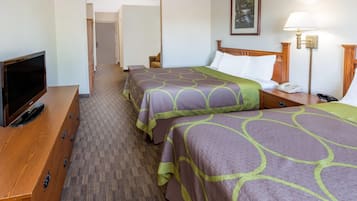 Habitación de hotel con dos camas, televisión, escritorio y lámpara.