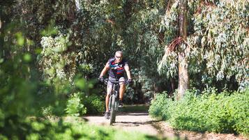 Ein Radfahrer auf einem Feldweg, umgeben von dichtem Grün.