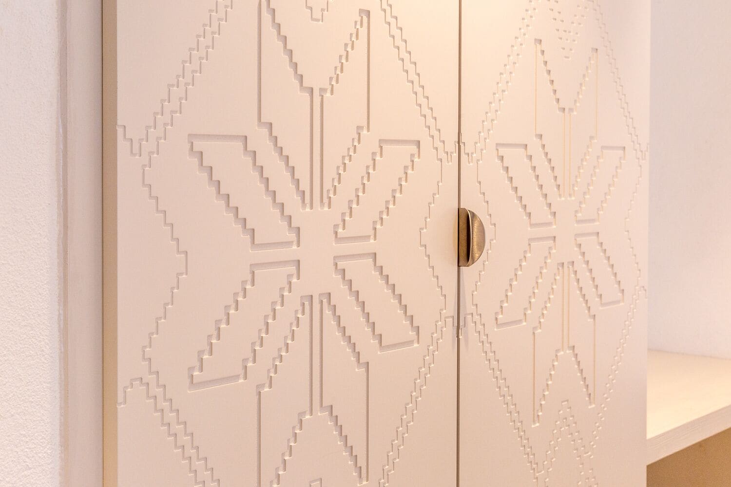 A wardrobe with geometric patterns and a central handle.
