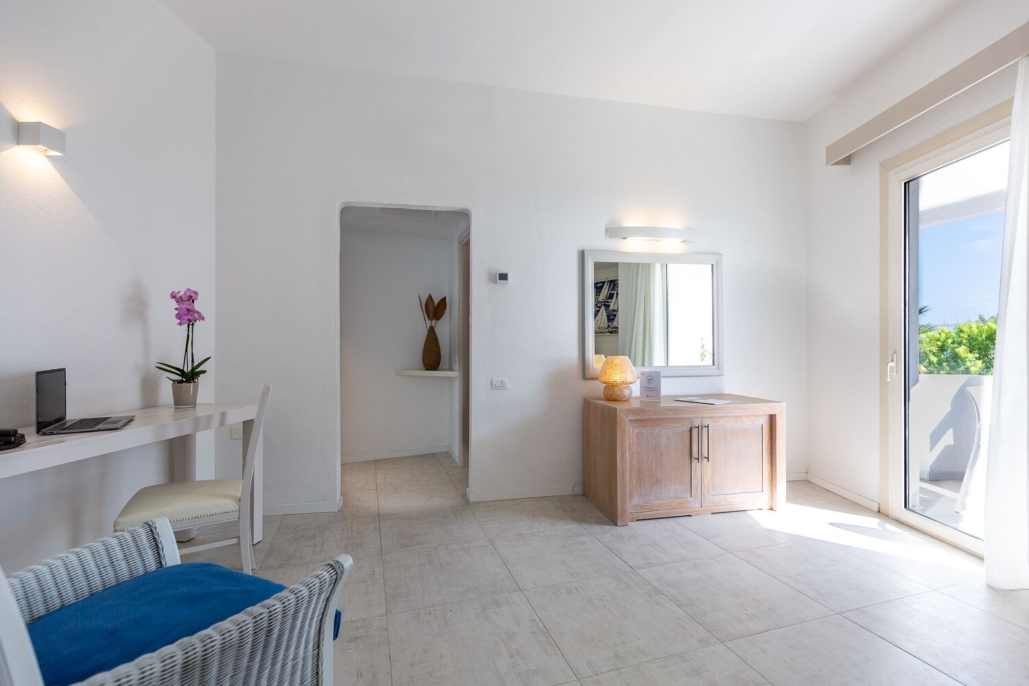 Una habitación de hotel moderna con escritorio, silla y un pequeño espacio de estar.