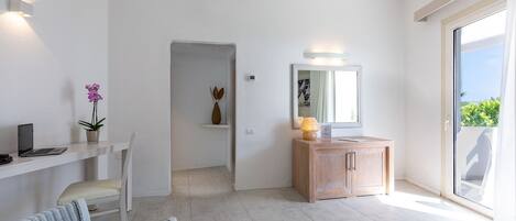 Una habitación de hotel moderna con escritorio, silla y un pequeño espacio de estar.