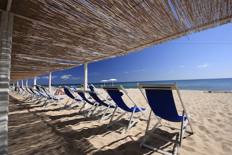 Privatstrand, Liegestühle, Sonnenschirme. Hotel Flamingo Resort