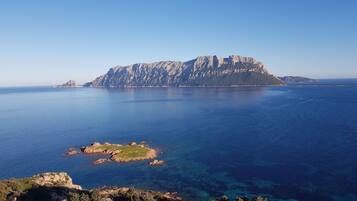 A coastal landscape with a prominent rocky island and a smaller island with vegetation.