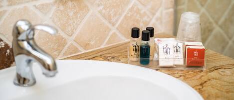 A bathroom sink with toiletries and a soap dispenser.