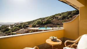 Un balcon donnant sur une piscine, entouré de verdure et de bâtiments.
