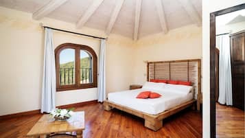 Une chambre à coucher avec un lit en bois, une petite table et une fenêtre avec des rideaux.