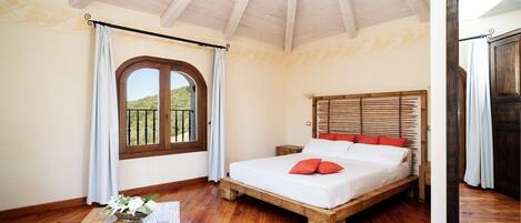 Une chambre à coucher avec un lit en bois, une petite table et une fenêtre avec des rideaux.