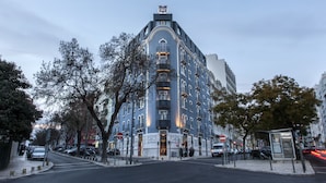 Un hotel de varios pisos con un diseño arquitectónico clásico, que cuenta con una entrada destacada y balcones.