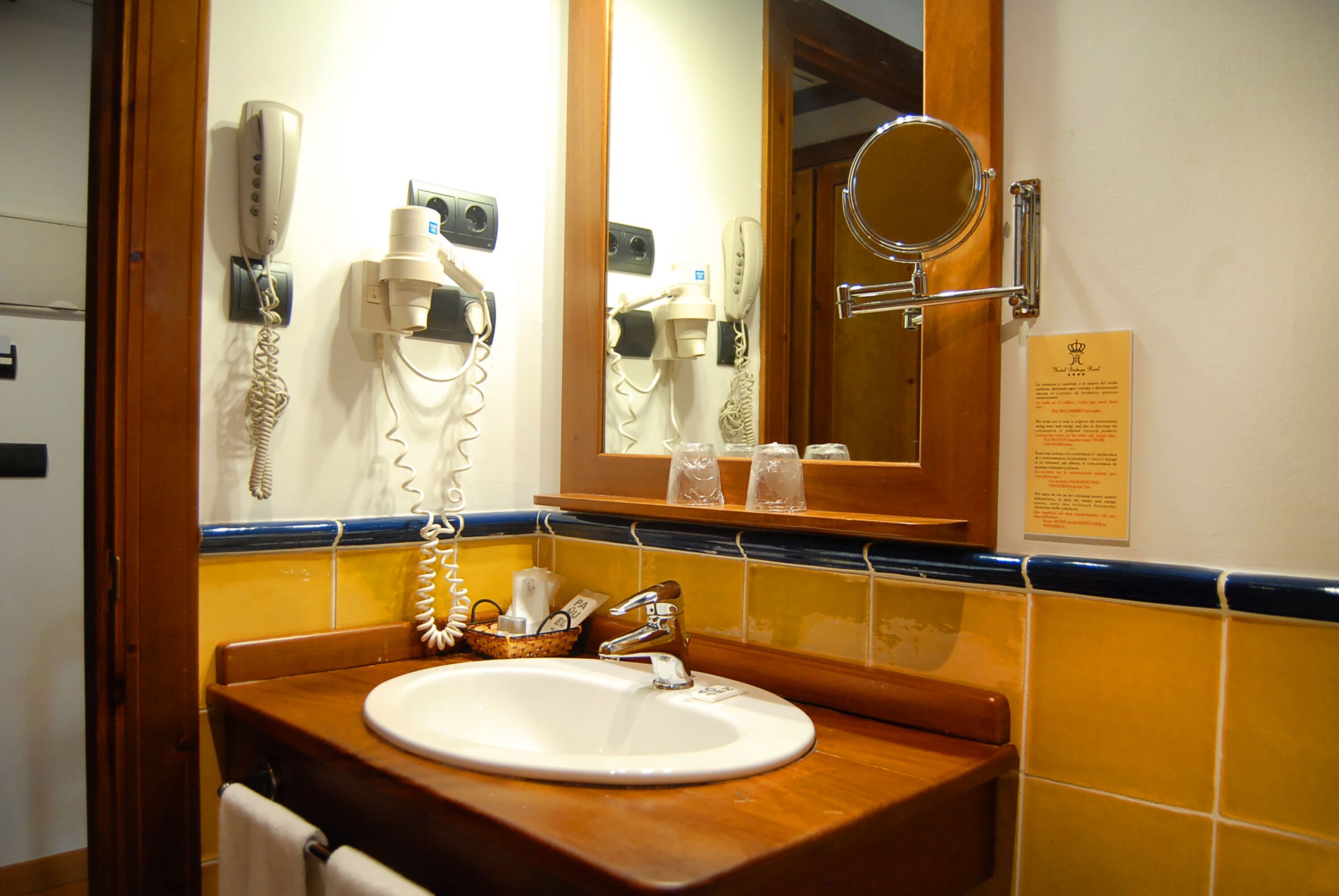 A bathroom with a sink, mirror, and hairdryer.