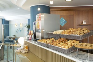 A buffet area with various baked goods and a coffee machine. - B&B Hotel Pescara (Pescara)