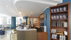 A modern cafe with a counter, seating area, and shelves stocked with coffee bags and kitchenware. - B&B Hotel Pescara (Pescara)