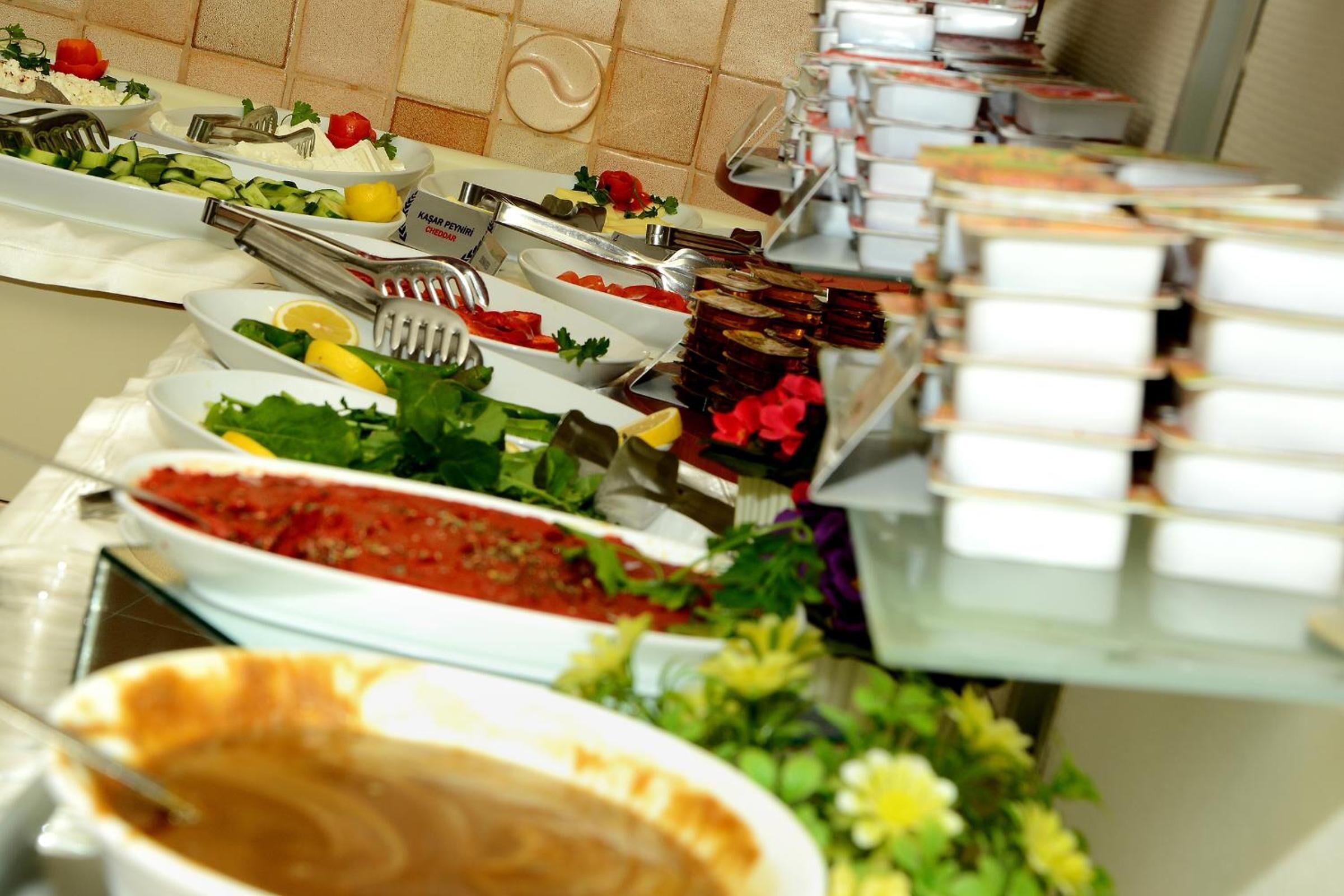 Um buffet com diversos alimentos e utensílios.